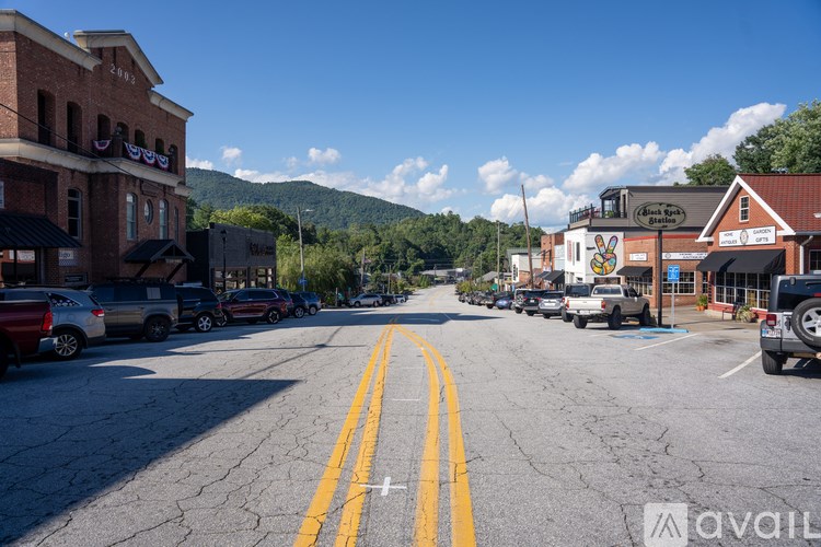 A street with a yellow line down the middle and cars parked on both sides.