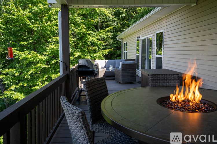 A patio with a fire pit and chairs.