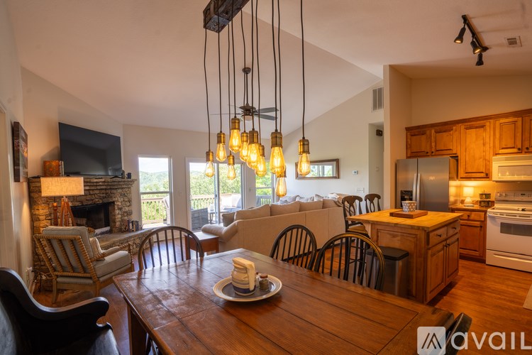 A modern kitchen with wooden cabinets and a dining table set for two.