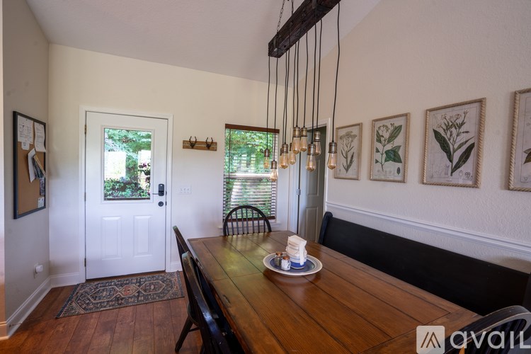 A dining room with a wooden table and chairs.