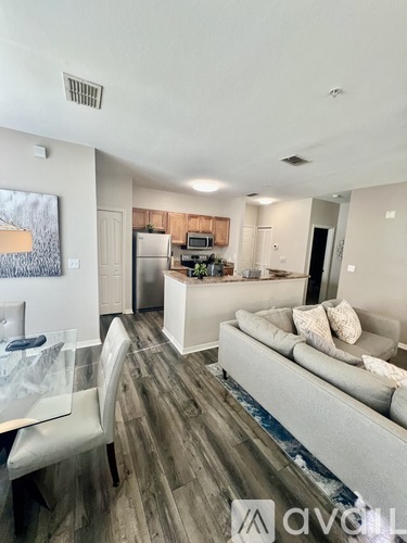 A modern living room with a grey couch and a wooden floor.