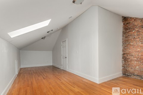 A room with a brick wall and wooden flooring.