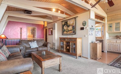 A living room with a brown leather couch and a wooden coffee table.