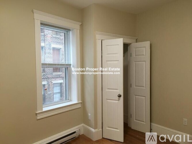 A room with a window and a door is available for rent.