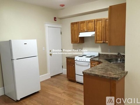 A kitchen with wooden cabinets and a white fridge.