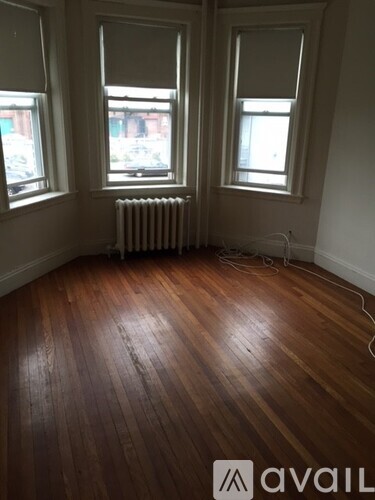 A room with wooden floors and two windows.