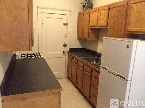 A kitchen with wooden cabinets and a black countertop.