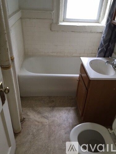 A bathroom with a toilet, sink, and bathtub.