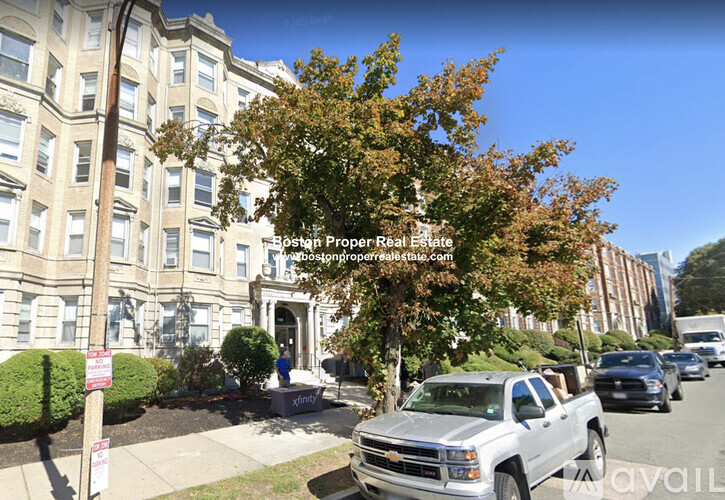 A street view of a residential area with a white Chevrolet truck parked on the side of the road.
