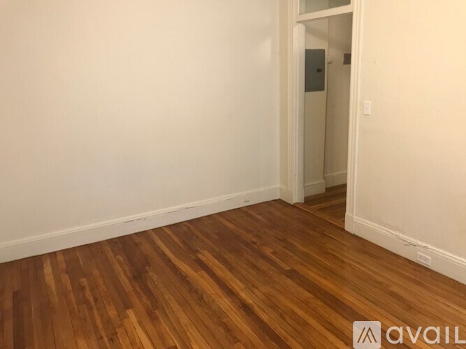 A room with wooden flooring and a white door.