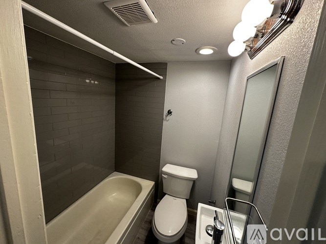 A bathroom with a tub, toilet, and sink.