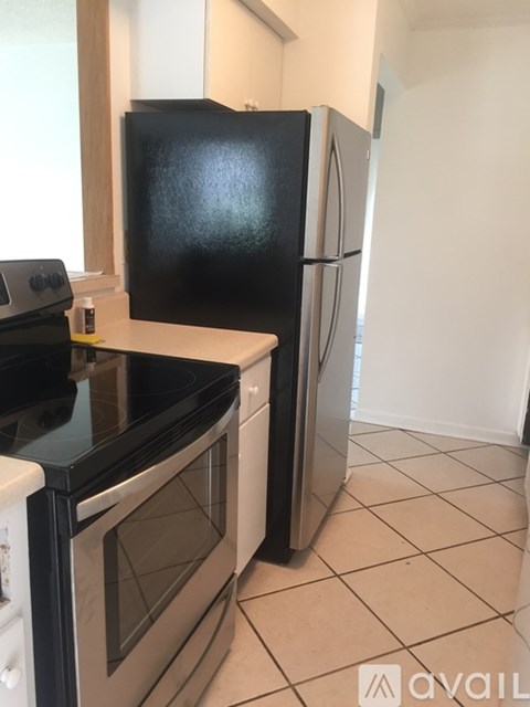 A black fridge and stove in a kitchen.