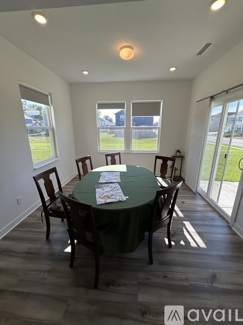 A dining room with a green table and chairs.