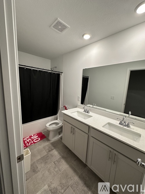 A bathroom with a toilet, sink, and mirror.