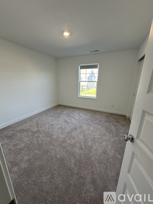 A room with a carpeted floor and a window showing a blue dome.