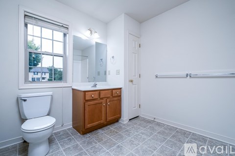 A spacious room with white walls and carpeted floor.