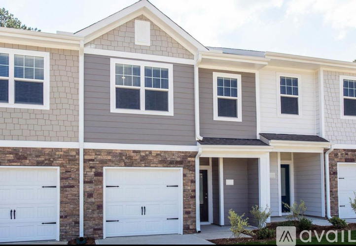 A two-story house with a garage is available for sale.