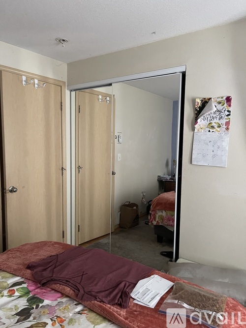 A bedroom with a bed, a wardrobe, and a mirror.