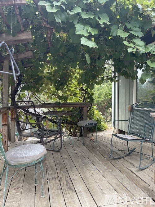 A wooden deck with a chair and a table.