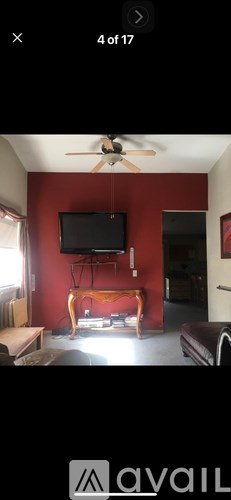 A living room with a television and a fan.