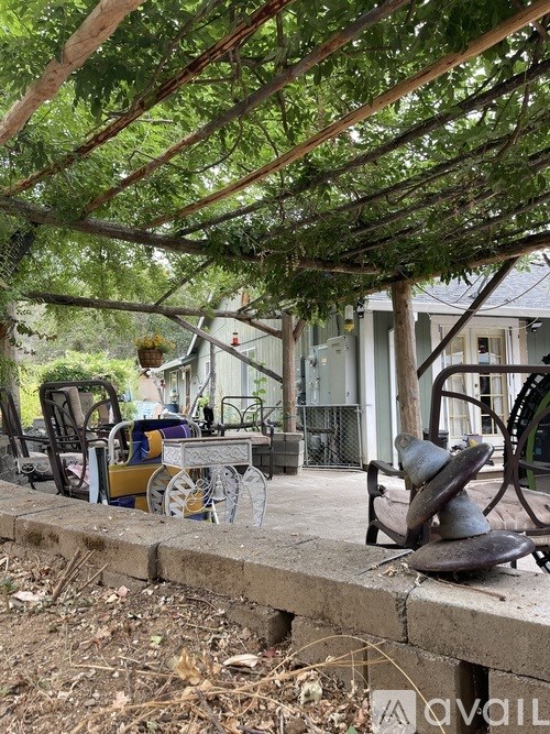 A patio with a table and chairs under a pergola.