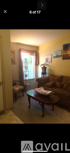 A living room with a brown couch and a coffee table.