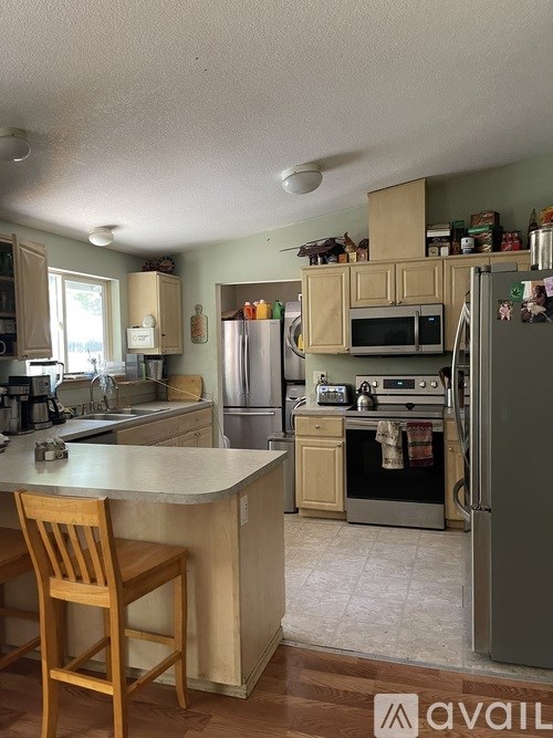 A kitchen with a refrigerator, oven, and microwave.