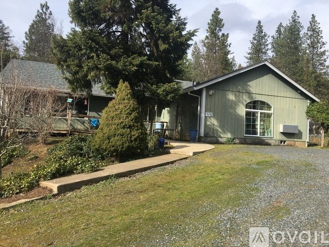 A house with a grey roof and a green lawn in front.