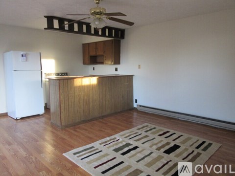 A kitchen with a white fridge and wooden cabinets.