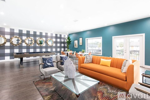 A living room with a glass coffee table and a sofa with a throw pillow.