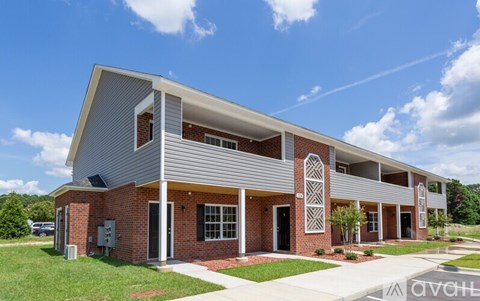 A modern building with a red brick facade and a white roof.