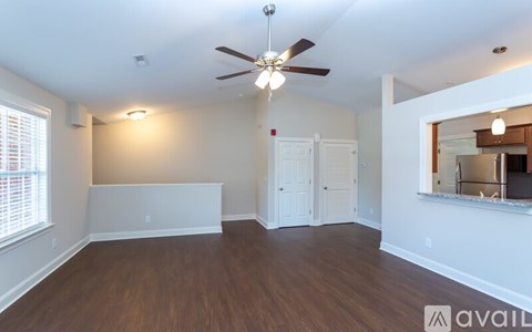 A room with a ceiling fan and two windows.