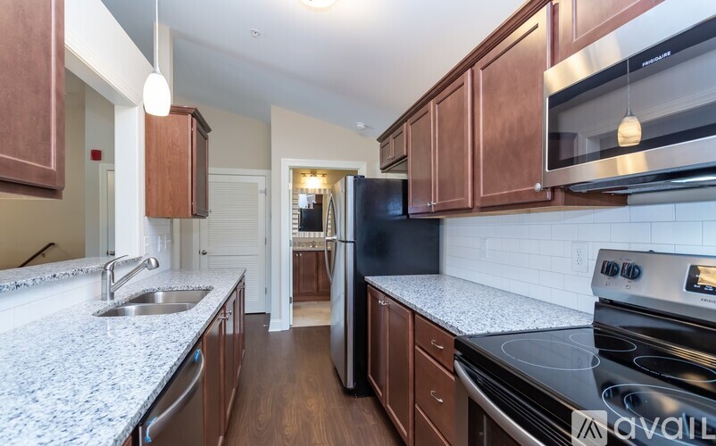 A kitchen with brown cabinets and a granite countertop.