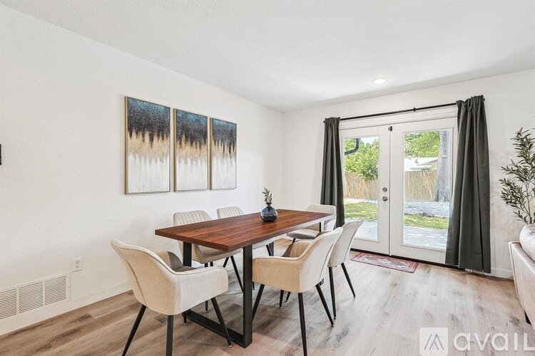 A dining room with a wooden table and chairs.