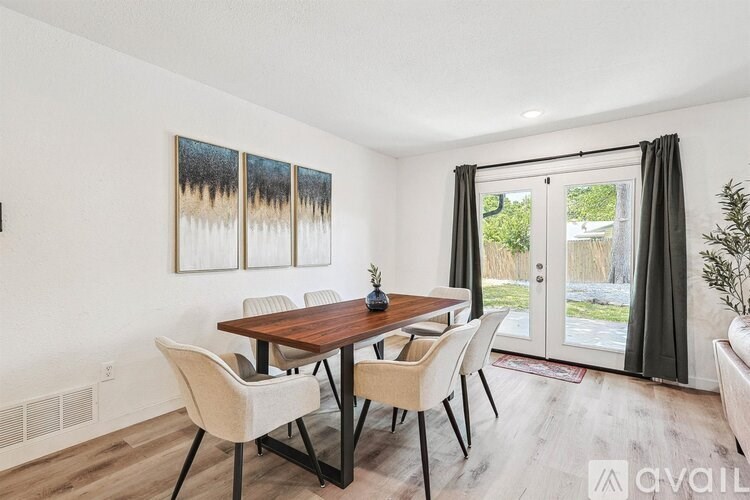 A dining room with a wooden table and chairs.