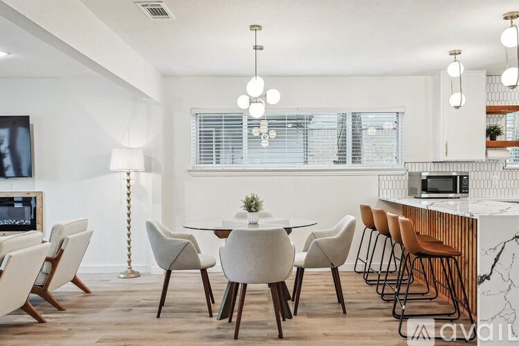 A modern dining room with a white table and chairs.