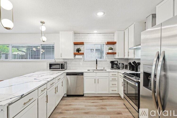 A kitchen with white cabinets and stainless steel appliances.