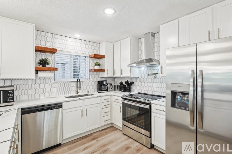A kitchen with white cabinets and stainless steel appliances.