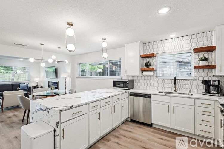 A modern kitchen with white cabinets and a large island.