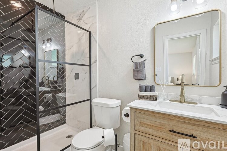 A bathroom with a toilet, a sink, and a mirror.