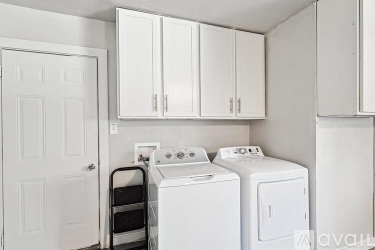 A white laundry room with a washer and dryer.