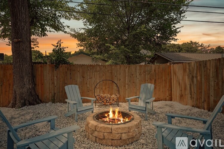 A backyard with a fire pit and chairs.