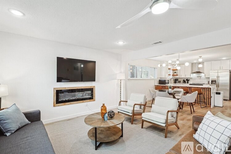 A living room with a grey couch, a coffee table, and a television.