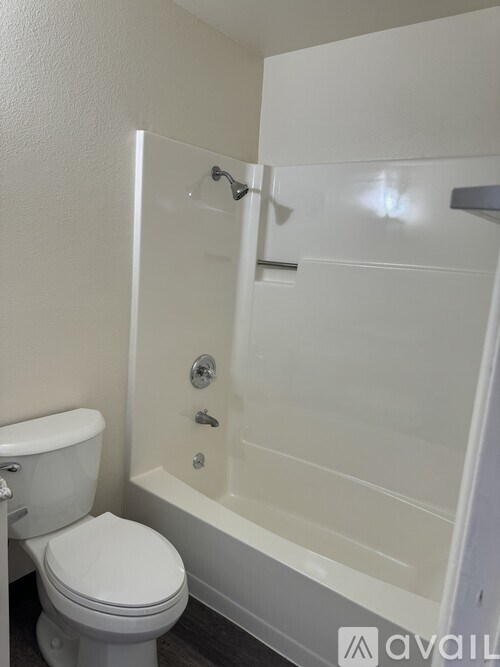 A white toilet sits next to a white bathtub in a bathroom.