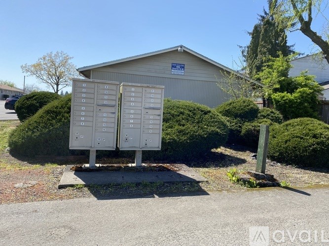 Two mailboxes stand in front of a building with a blue sign.