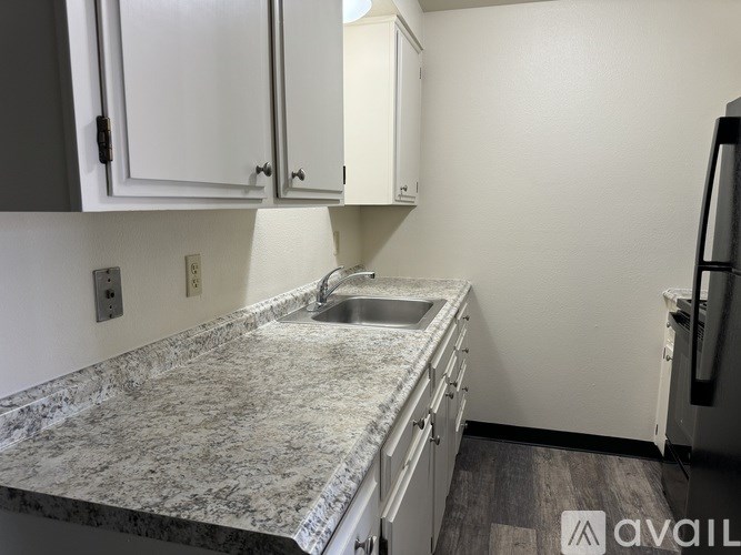 A kitchen with a granite countertop and white cabinets.
