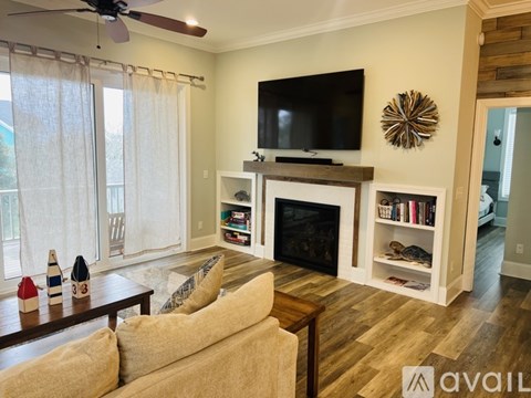 A living room with a fireplace and a television on the wall.