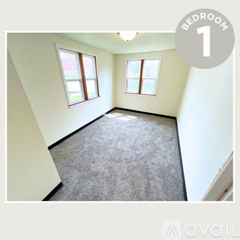 Bedroom 1 has a grey carpet and two windows.