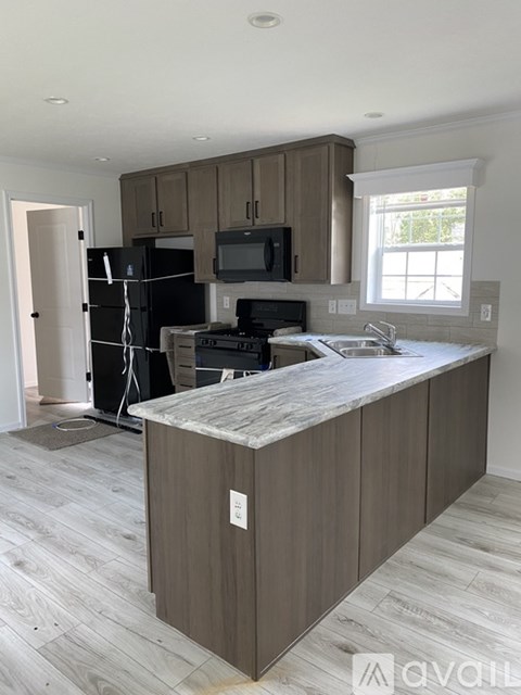 A kitchen with a refrigerator, microwave, and oven.