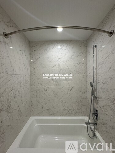 A white bathroom with a marble wall and a white tub.